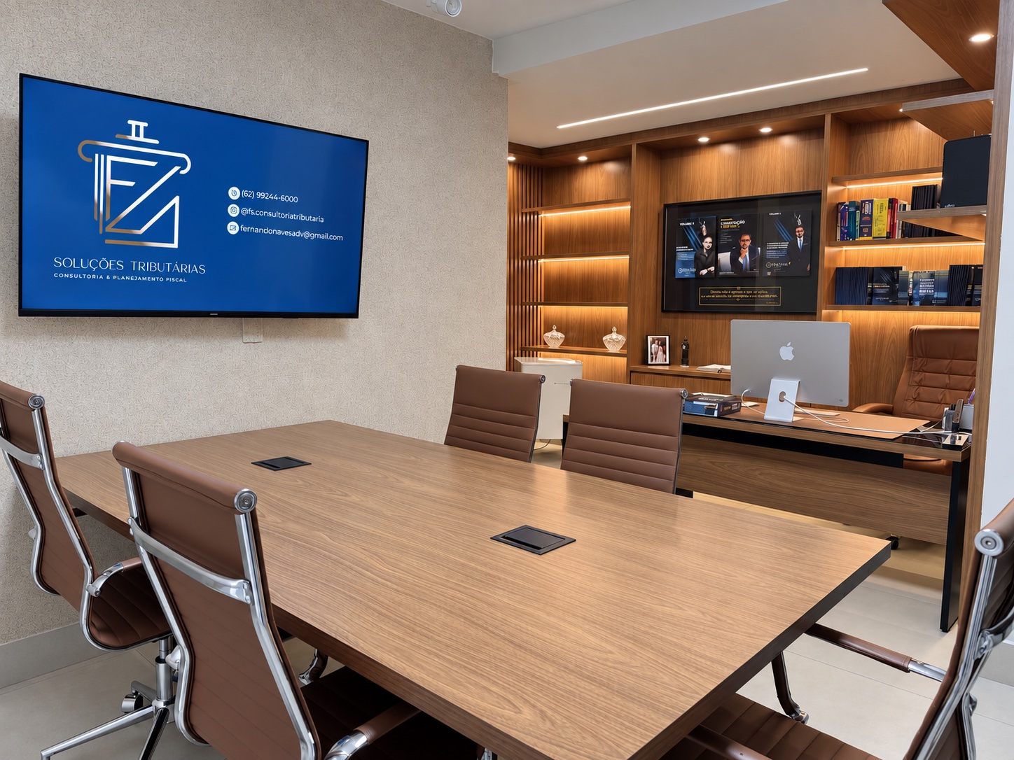 Sala de reuniões da FS com mesa ampla, cadeiras e escritório ao fundo